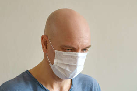 Bald man in a protective medical mask close-up, the concept of protection from the pandemic.