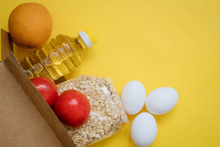 Food in a cardboard box on a yellow background.の写真素材