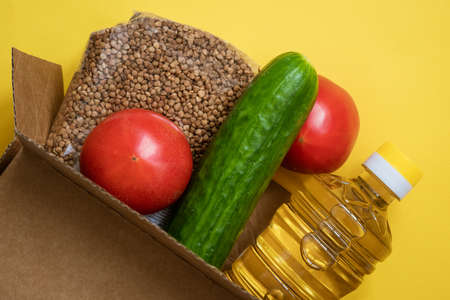 Food in a cardboard box on a yellow background.の写真素材