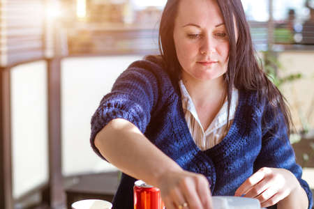 A woman is sitting at a table in a cafeの写真素材
