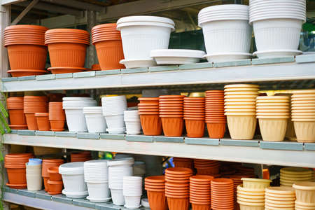 Plastic flower pots on the shelf in the store stand, a variety of sizes and colors for gardeningの写真素材
