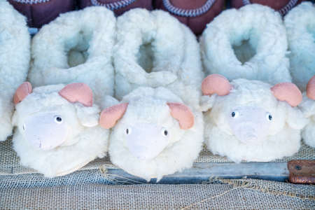 cute fluffy fur Slippers made of sheepskin stand in a row