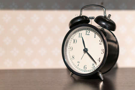 beautiful black alarm clock stands on the table
