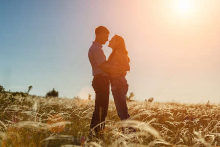 silhouette of two lovers at sunset in the fieldの写真素材