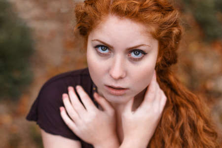 portrait of a sad red-haired girl, sadness and melancholy in her eyesの写真素材