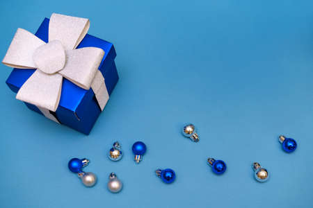blue gift box with christmas balls on a blue background, copy spaceの写真素材