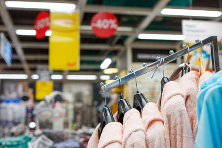 Warm women's dressing gowns on hangers in the storeの写真素材