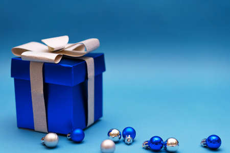 blue gift box with christmas balls on a blue background, copy spaceの写真素材