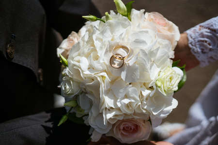 wedding bouquet with rings of the newlyweds on top, beautiful card