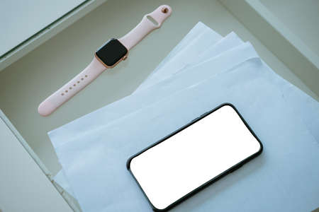 Phone and documents on the table with smart watch, business concept