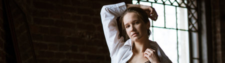 Portrait of a young woman in a white shirt on a dark background banner