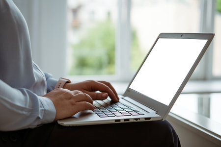 female hands working behind a laptop, without a face