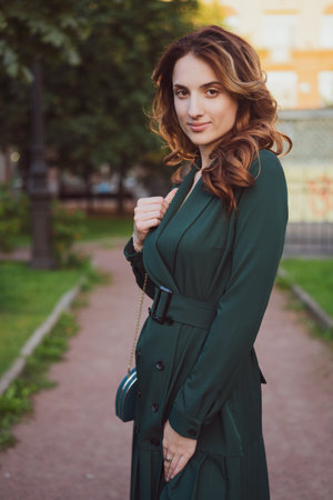 beautiful young woman in green dress outdoors smilingの写真素材