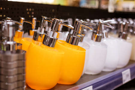 colorful plastic soap dispensers lined up on the store shelf