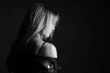 Portrait of a woman in a leather jacket and lingerie, black and white photo. Beautiful caucasian woman of nationality sensitive portrait on black backgroundの写真素材