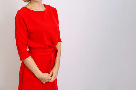 Business woman in a red dress on a light background posing in the studio. Photo without a faceの写真素材