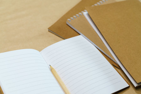Blank white notepad and pencil on paper background. Mock up, top view, copy space.の写真素材