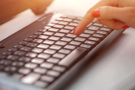 A woman clicks on internet search pages on computer keyboards to find what they are interested in, to search for information on the web. Data search concept. Finger with red manicureの写真素材