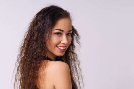 Portrait of a cute and shy young woman smiling. Young caucasian woman posing on a light background in the studio in a denim shirt.の写真素材