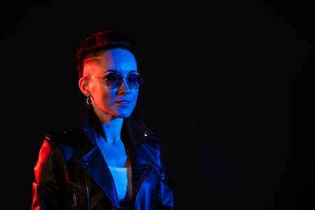 Night portrait of woman. Neon light. Positive attitude. Confident happy woman, wearing leather...