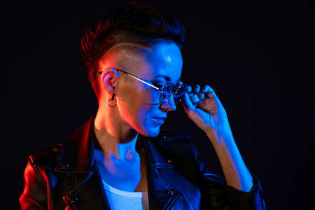 Night portrait of woman. Neon light. Positive attitude. Confident happy woman, wearing leather...
