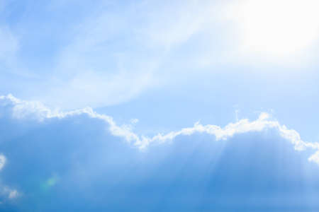 Simple beautiful gloomy blue sky with fluffy clouds on peaceful summer morning day as a background. Gray and white color blurred horizon texture photographyの写真素材