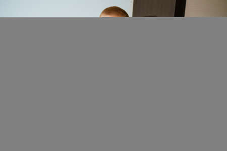 Kid plays with an old grandmother and teddy bear toy. Cheerful and smiling grandmother with her grandson. Cute toddler boy playing with senior woman sitting on sofa at homeの写真素材