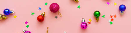 New years composition. Colored decoration balls and stars on pastel pink background. Christmas winter, new year concept. Flat lay, top view, copy spaceの写真素材