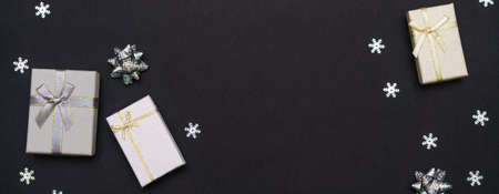 Top view christmas black dark background with gift boxes and sparkles with snowflakes. Merry christmas and happy new year greeting card with space for textの写真素材