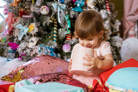 happy little girl on the background of the christmas tree playing