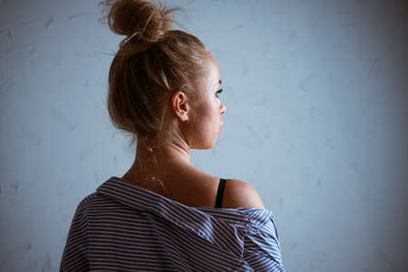 Portrait of a woman with a tail on her head against the background of a gray wallの写真素材