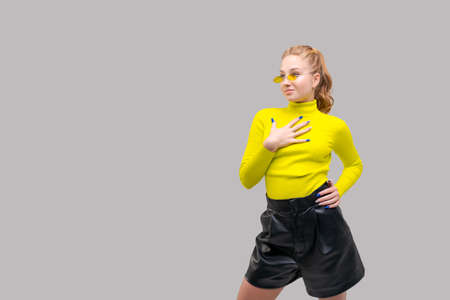 Portrait an attractive stunning cheerful slender girl, posing in bright yellow sweater and colored...