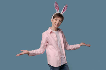 Photo pleasant young guy with funny childish mood gesturing with his hands and looking at camera,...