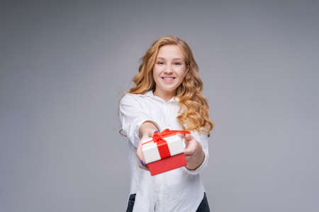 Photo cheerful positive girl hold gift clothes white shirt jeans black, long wavy hair. Isolated...