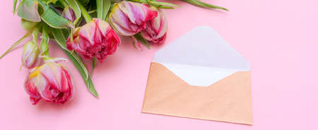 Bouquet tulips and an envelope written on pink background. Concept international womens day, mothers...