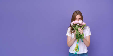 Flowers for special occasion. Happy young lady holding bouquet pink peonies in front her face...