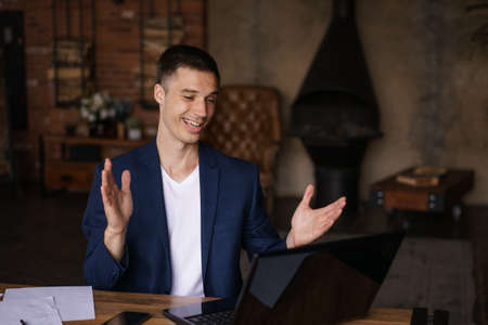 Serious caucasian businessman accountant accounting analyst holding documents looking at computer screen over laptops doing online trading market thinking technology research working at home officeの写真素材