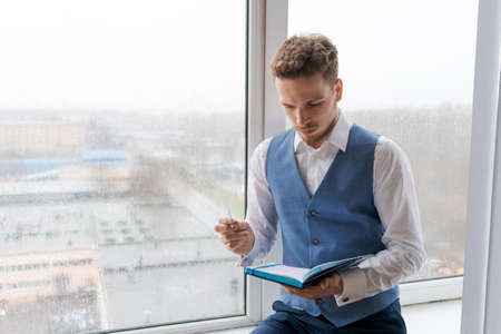Caucasian businessman writing in notebook, male hands holding pen making notes planning new...