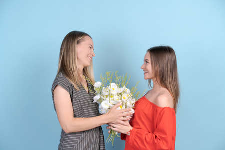 Fashionable attractive cheerful mother and daughter enjoying holiday together while having big...