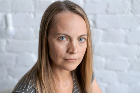 Portrait with shot happy middle-aged blonde woman Smiling looking at camera feels happy pose,...