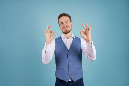 Image successful man in formal wear smiling at camera, isolated on blue background. Stylish young...
