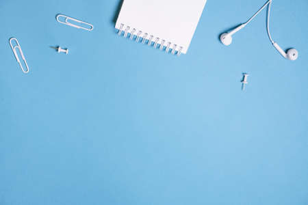 Headphones, open notebook Music concept. Top view with copy space on blue background