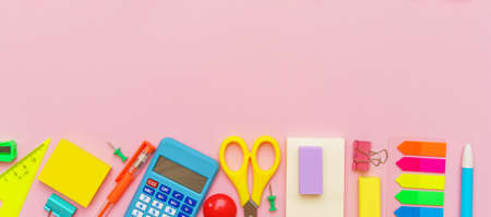 Stationery colorful writing supplies pens pencils, back to school concept. Office supplies on a pink...