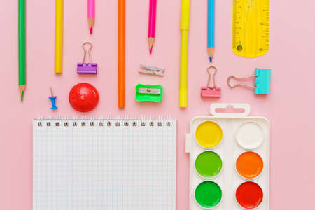 Supplies creative tools for school creative work on pink background with pattern stationery, colored paints brushes pencils, pens notepad on a spiral copy space, flat set, mock upの写真素材