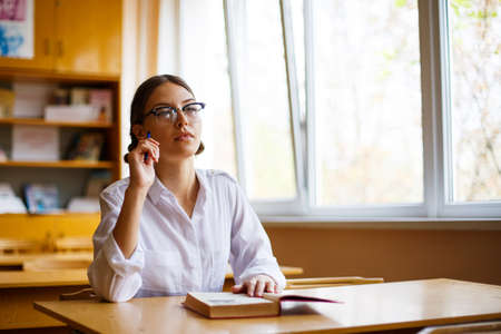 Education in classroom concept image student writing article or notes in lecture room while participating in study session of academic development girl Student conducting pencil examの写真素材