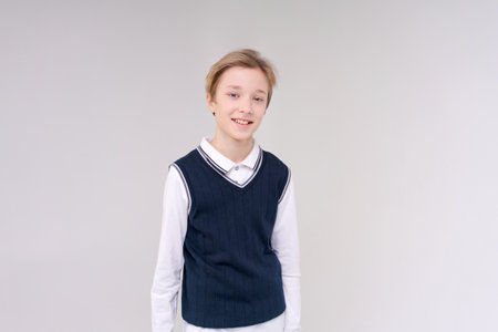 Photo an adorable young happy boy looking at camera wearing a white shirt and a blue tank top in a...