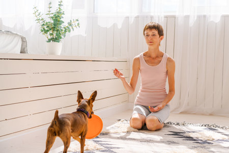 Woman practicing exercising with dog to enjoying and relaxing with yoga. Spend time and play with your dog at home. Rest love for dog conceptの写真素材
