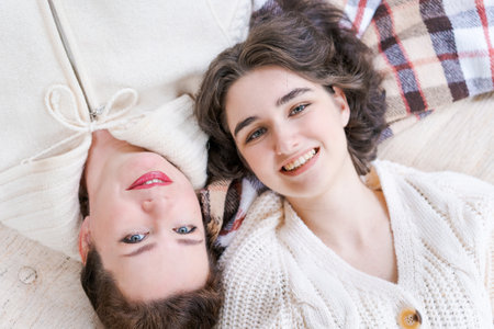 Relax, laughing and senior mother and daughter with coffee cup for home conversation, talking and bonding together. Happy family, tea and on veranda embracing and rolling in a warm blanketの写真素材