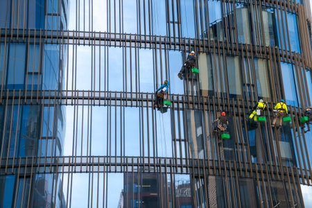 Window cleaners wash the glass of an office building at a heightの写真素材