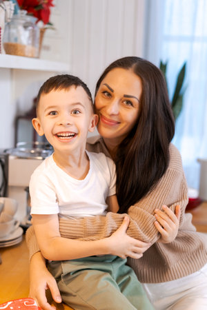 Fun mom and son playing in kitchen, happy spending time on Christmas Eve and New Years Eveの写真素材